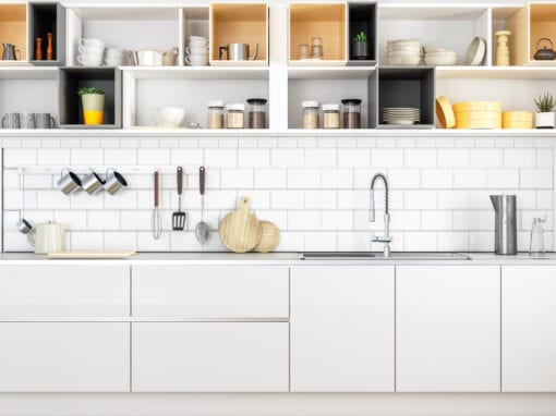 Modern kitchen with white cabinets, open shelves displaying dishes and jars, utensils hanging over a white tile backsplash, and a sink with a tall faucet—all designed to keep pantry pests out while staying stylish and organized.